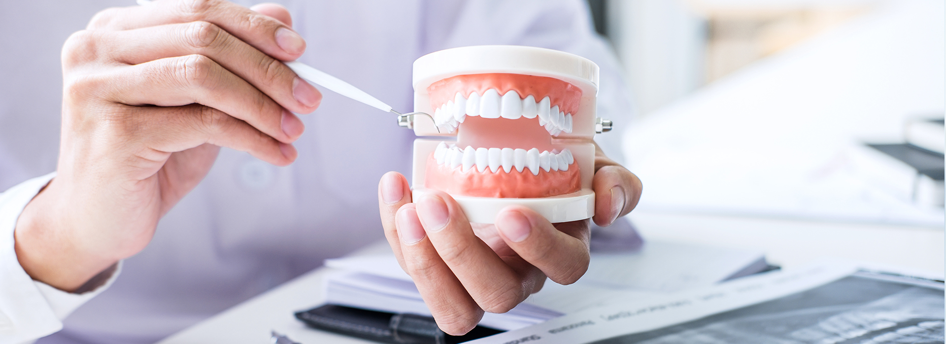 A person holding a toothbrush and a cup of water, with a focus on dental hygiene.